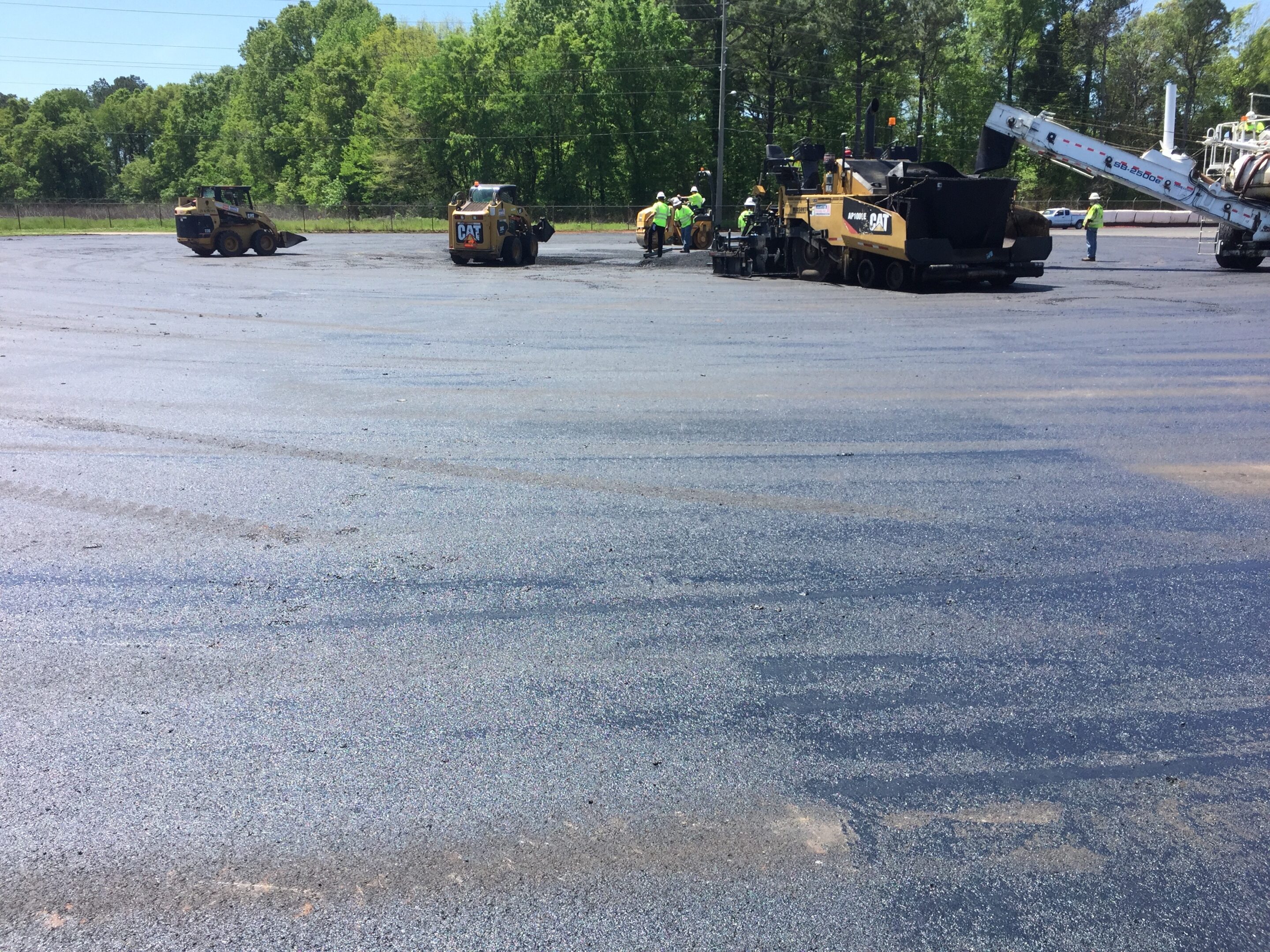 IMG_1353 Heavy machinery paving a large asphalt surface on a sunny day.