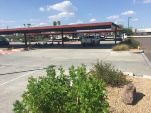 A gas station with a red roof under a blue sky with some clouds.