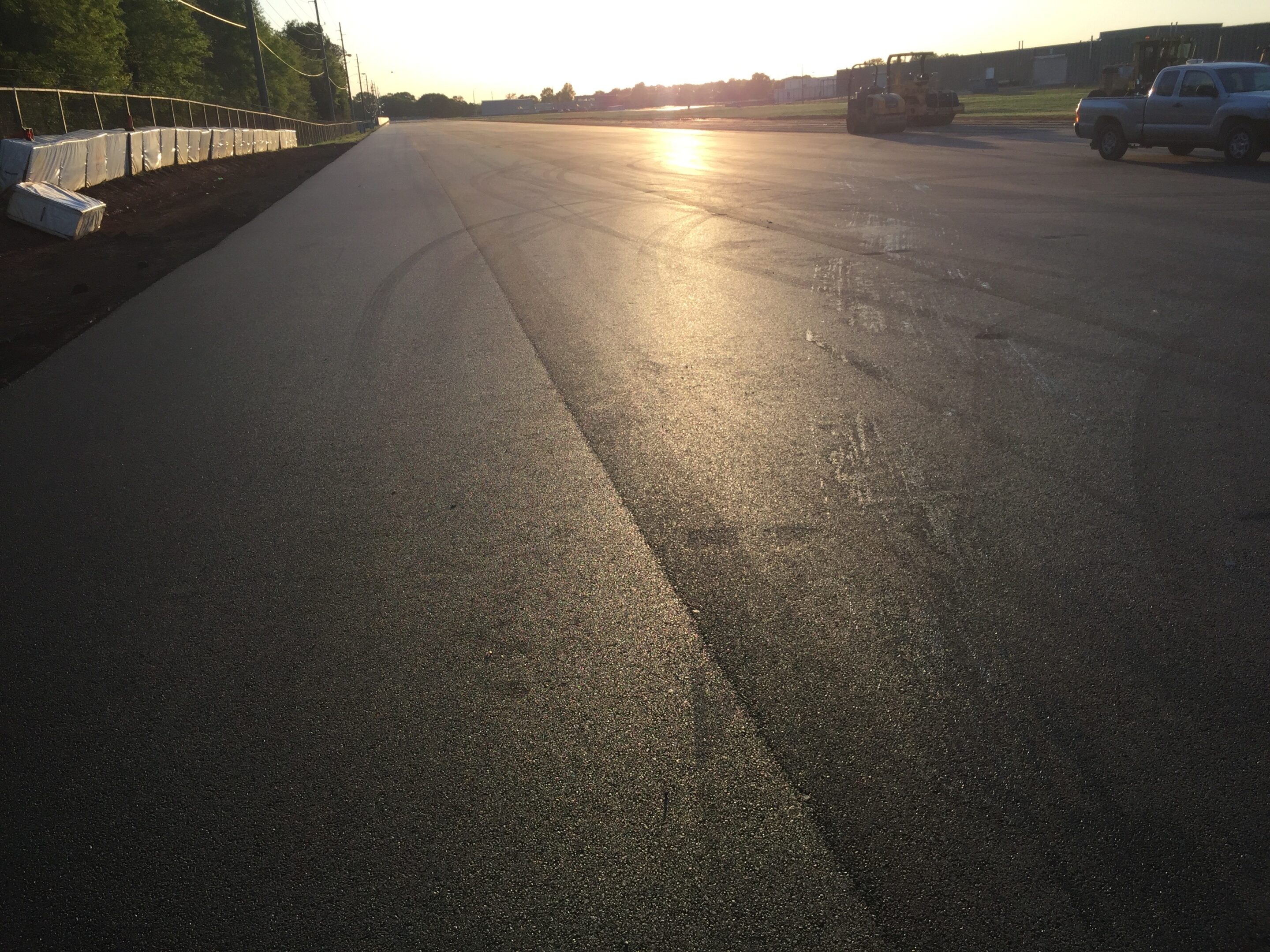 SUMITOMO 1 Smooth, freshly paved asphalt road with sunlight reflecting.